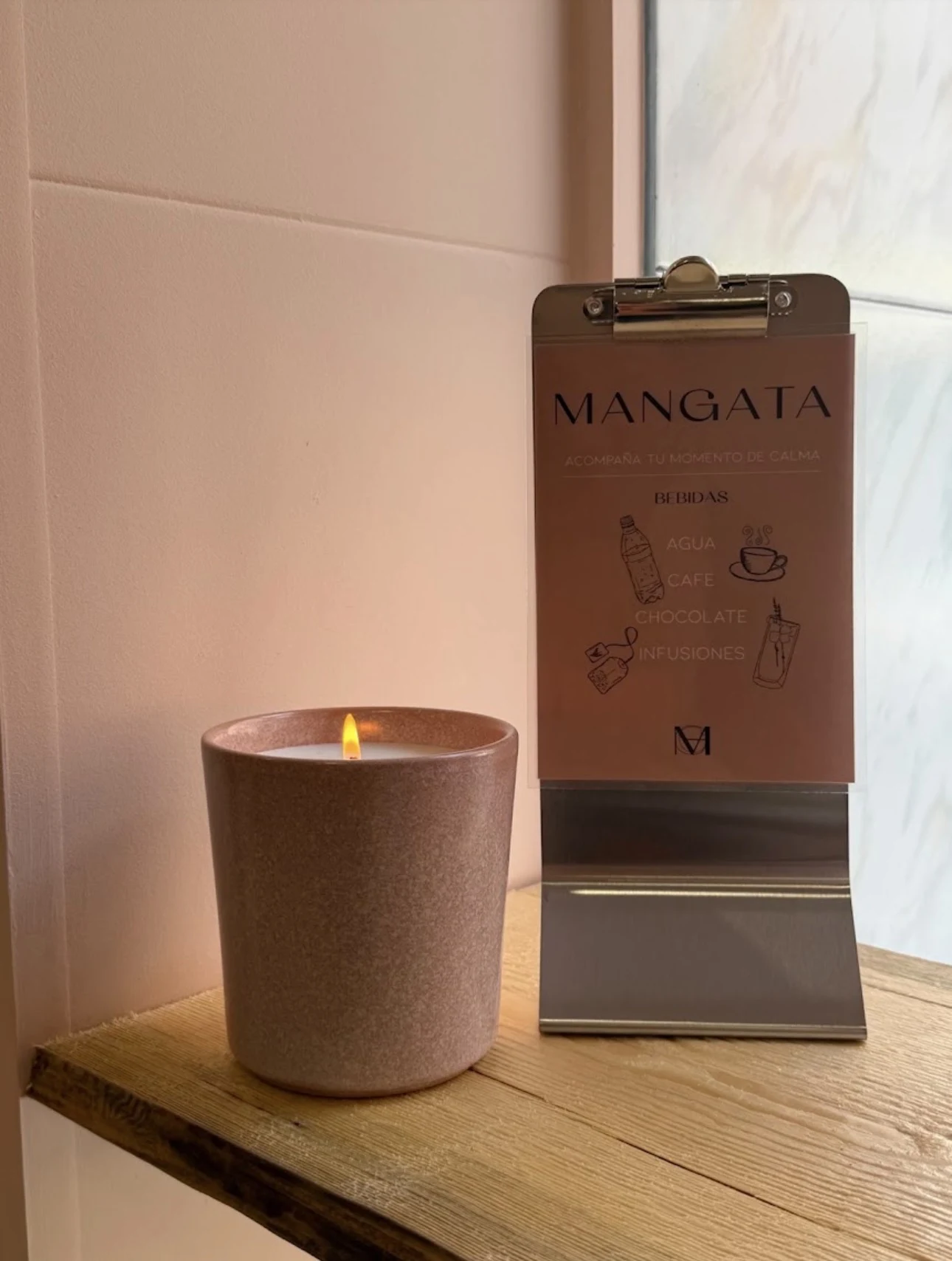 Vela y carta Mangata sobre una mesa