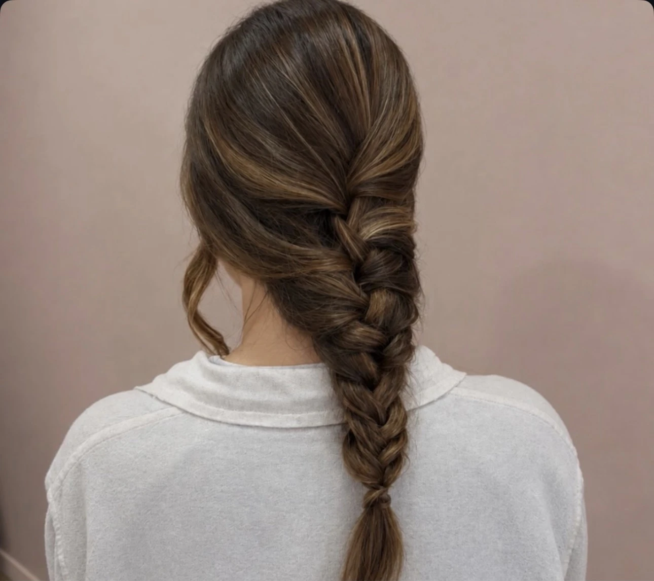 Trenza recogida sobre una blusa blanca